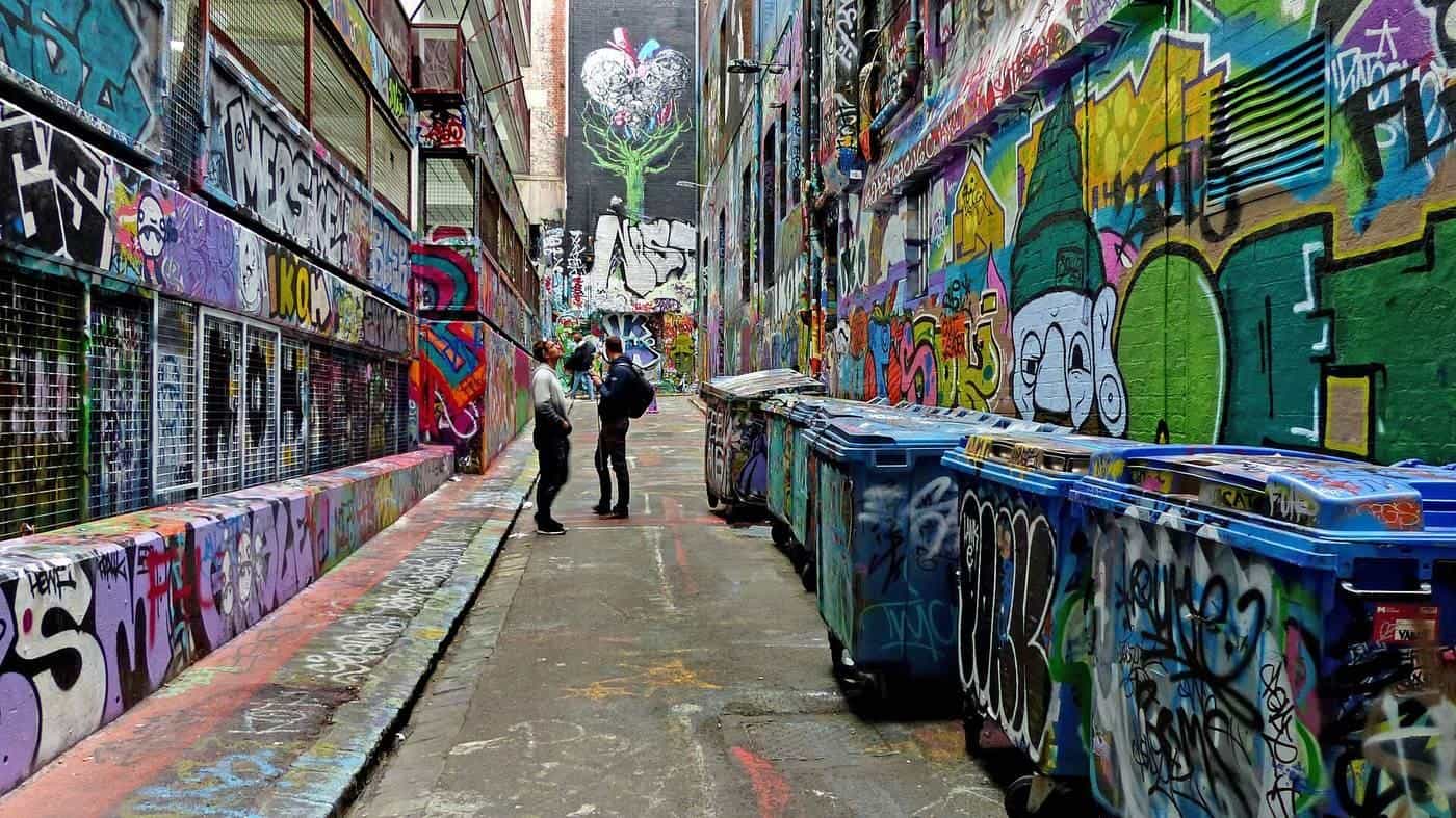 A laneway in central Melbourne with every wall and bin covered in colourful street art