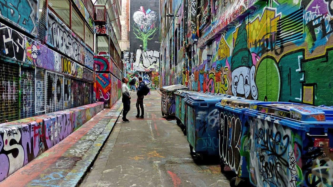A laneway in central Melbourne with every wall and bin covered in colourful street art