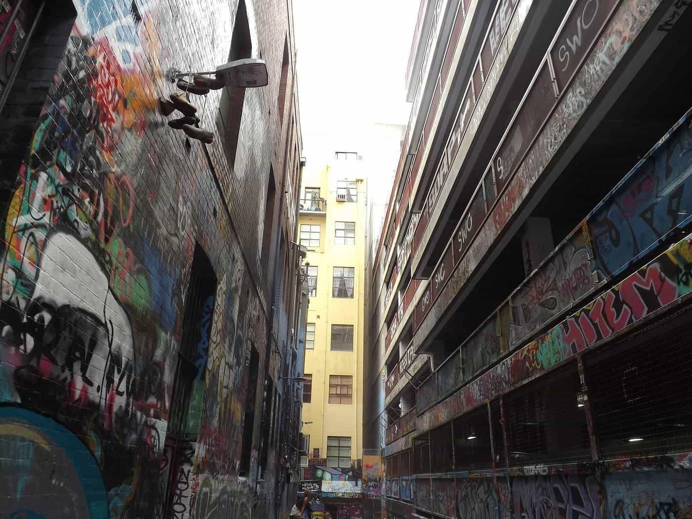 Painted walls and pipes in a narrow Melbourne laneway covered in street art