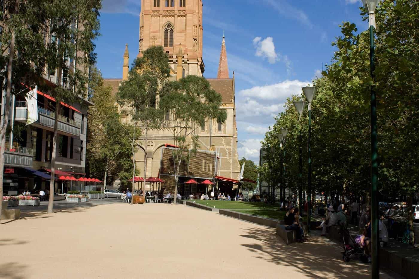 City Square in Melbourne with paved open space, trees and a cathedral spire behind